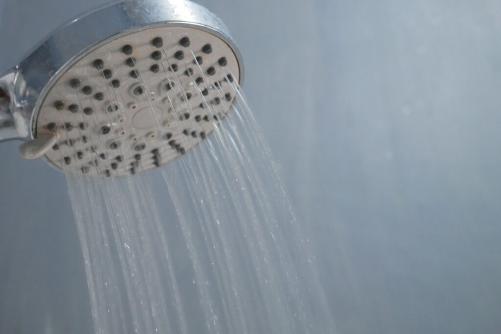 a showerhead with a trickling stream of water due to low water pressure